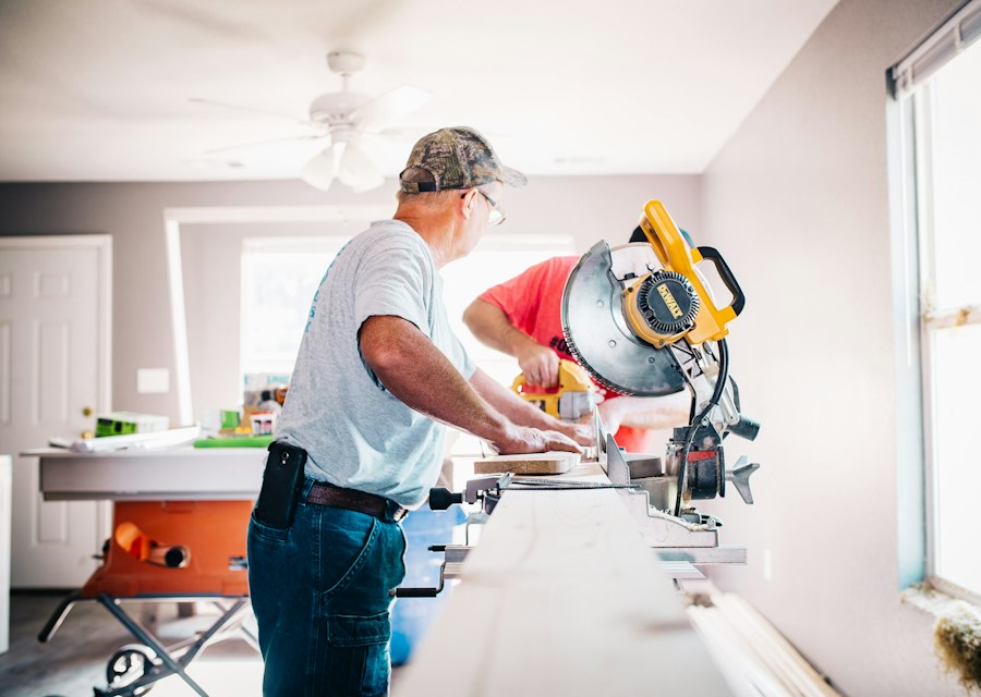 Carpenter working at a miter saw cutting trim to size